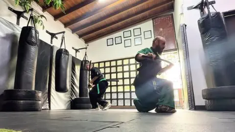 Práctica de espada coreana en el dojo, junto a los sacos de boxeo